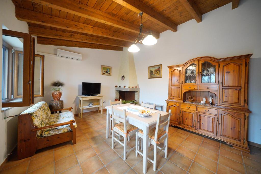 un soggiorno con tavolo bianco e divano di L'oliveto a Nuxis