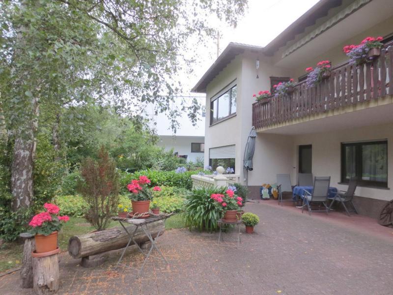 a house with a balcony with flowers on it at Ferienwohnung Haus Sonnenschein in Trassem