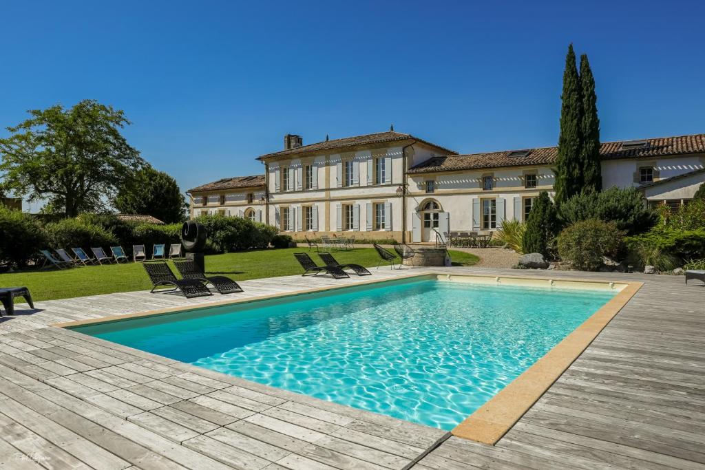 a swimming pool in front of a large house at Bordeaux-Blaye-St-Emilion-Arcachon-Domaine de Cézac in Cézac