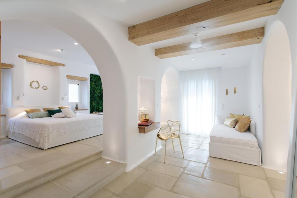 a white bedroom with two beds and a table at Euphoria Downtown in Naxos Chora