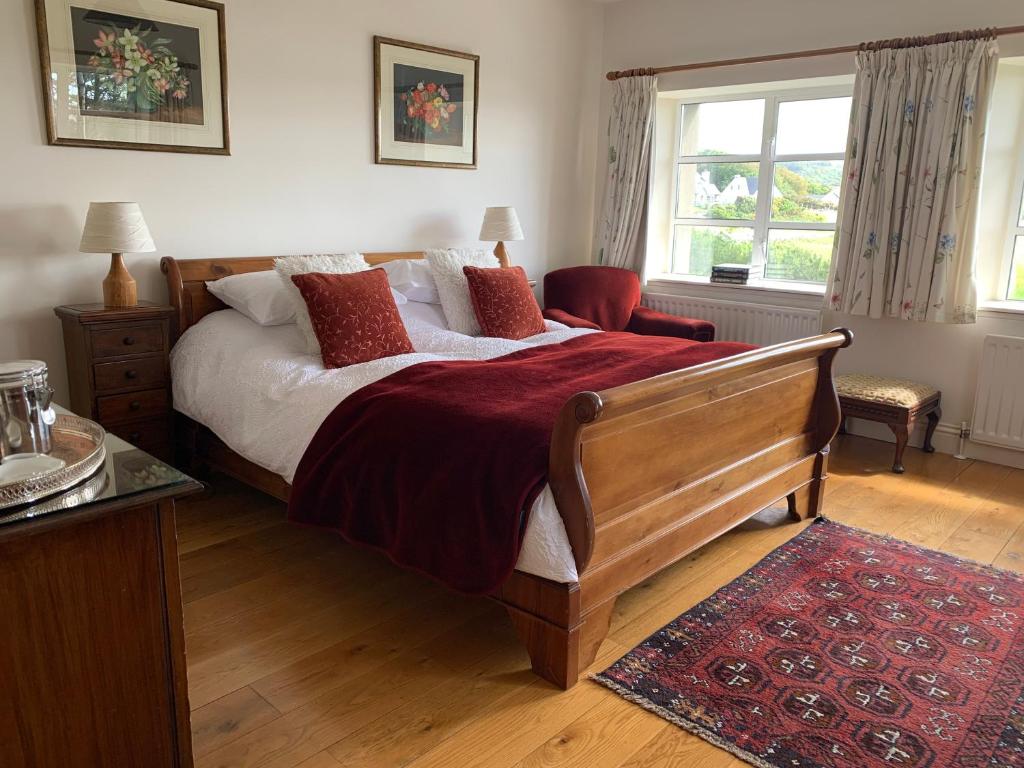 um quarto com uma cama, uma cadeira e uma janela em The Mill em Dunfanaghy