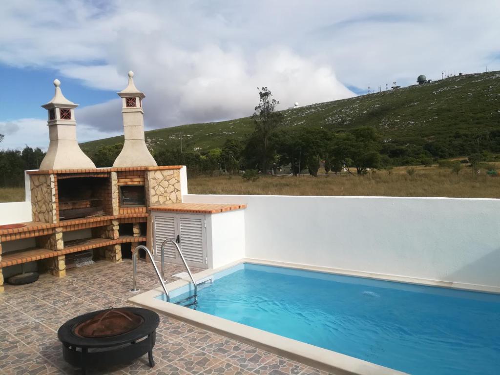 einen Pool mit einem Wellnesscenter neben einem Pool in der Unterkunft Montejunto Villas-Casa do Esquilo in Cadaval