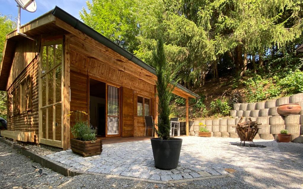 eine kleine Hütte mit einem Topfbaum davor in der Unterkunft NEU! Chalet Ilztal in Hutthurm