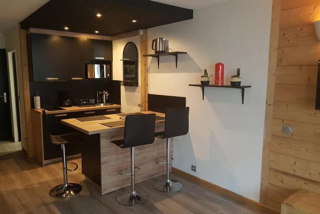 a kitchen with a counter and bar stools at Studio rénové - Val Claret centre - Exposition sud in Tignes