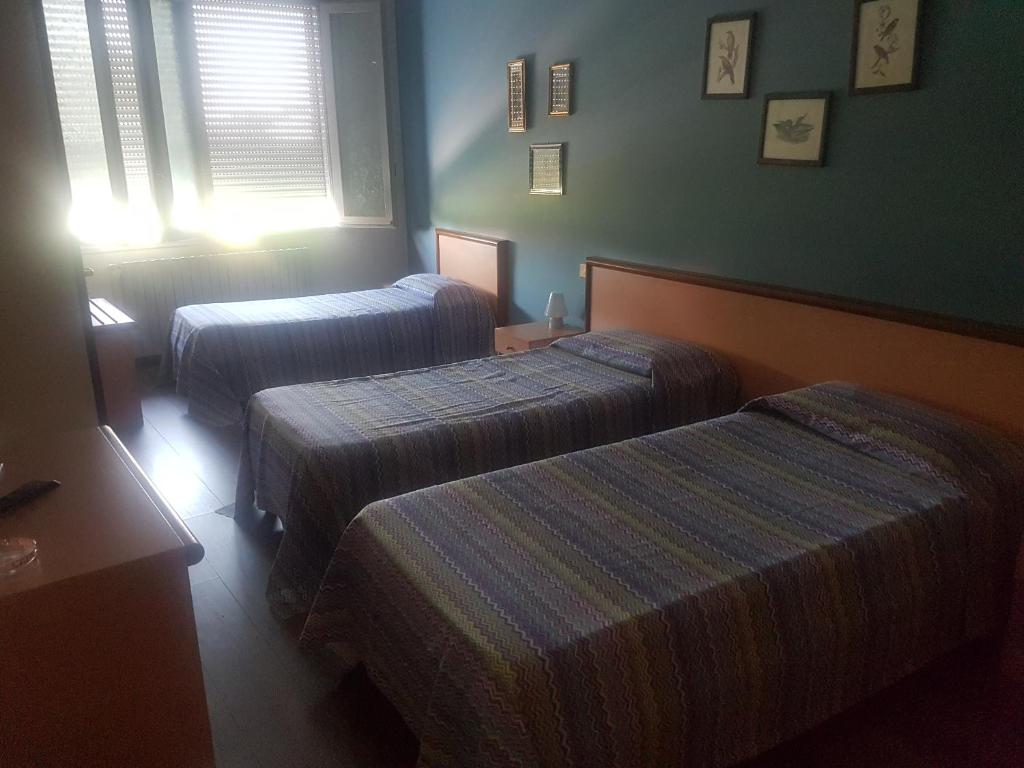 a hotel room with two beds and a window at Albergo Fonda in Villarotta