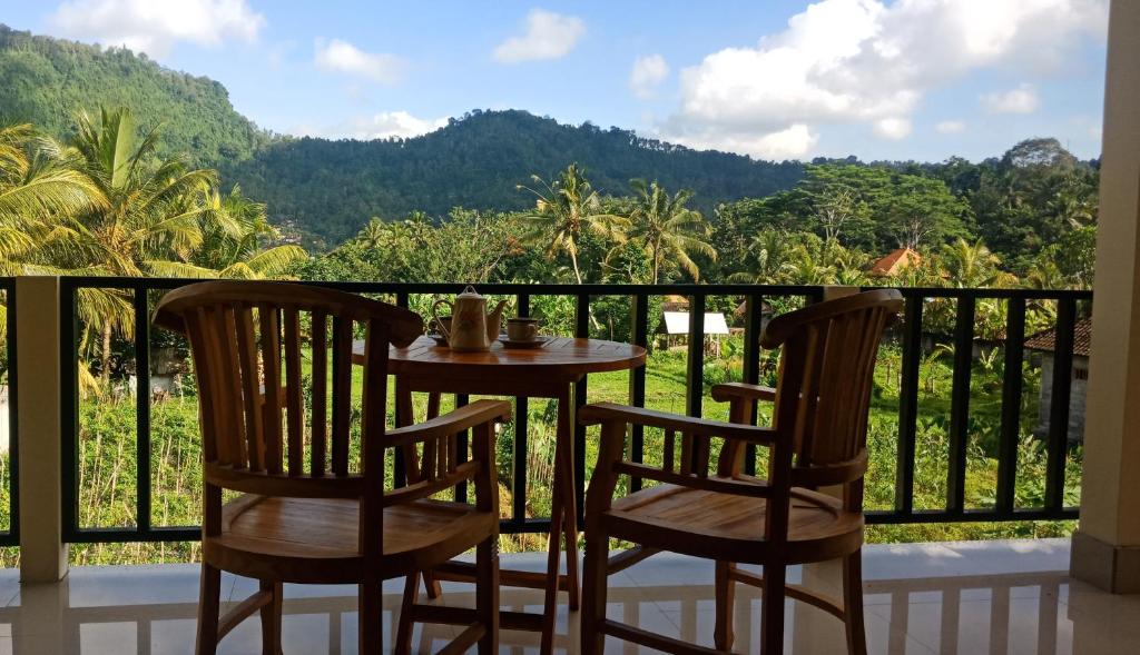 einen Tisch und zwei Stühle auf einem Balkon mit Aussicht in der Unterkunft Mantra Guesthouse in Sidemen