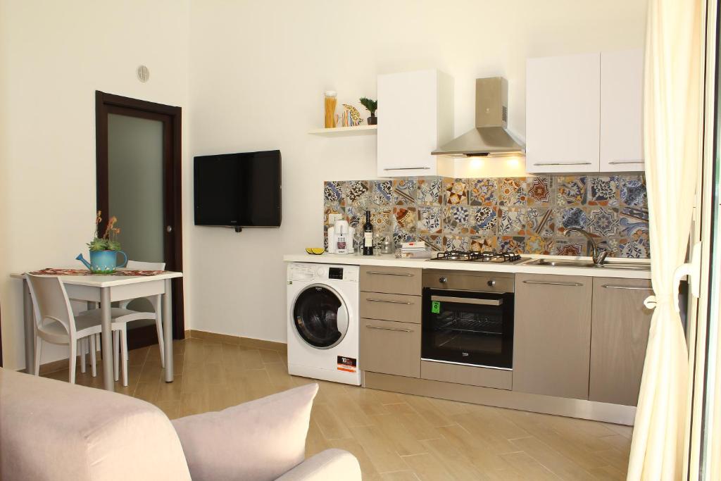 a kitchen with a washing machine and a table at Ciuri di Sicilia in Capaci