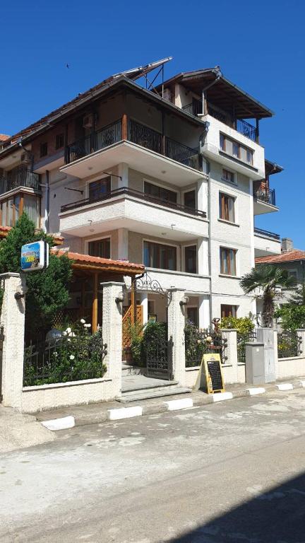 a large white building on the side of a street at Guest House Lazur in Obzor