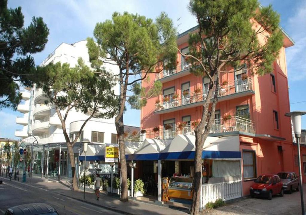 un edificio en una calle con árboles delante en Hotel Moderno, en Lido di Jesolo