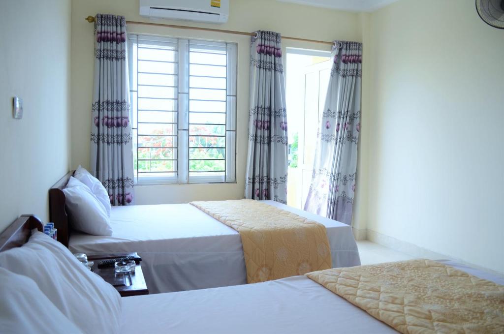 1 dormitorio con 2 camas y ventana en Khách sạn Phương Dung en Cửa Lò