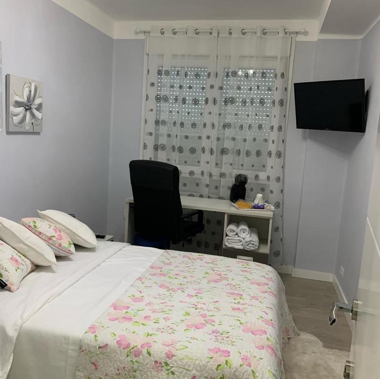 1 dormitorio con cama, escritorio y silla en La Rosa Azul Rooms, en Ponferrada