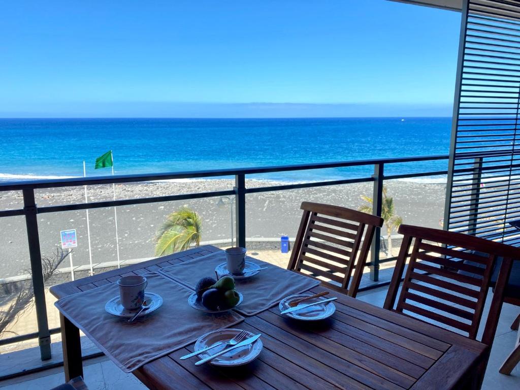 a table on a balcony with a view of the beach at Puerto playa in Tazacorte