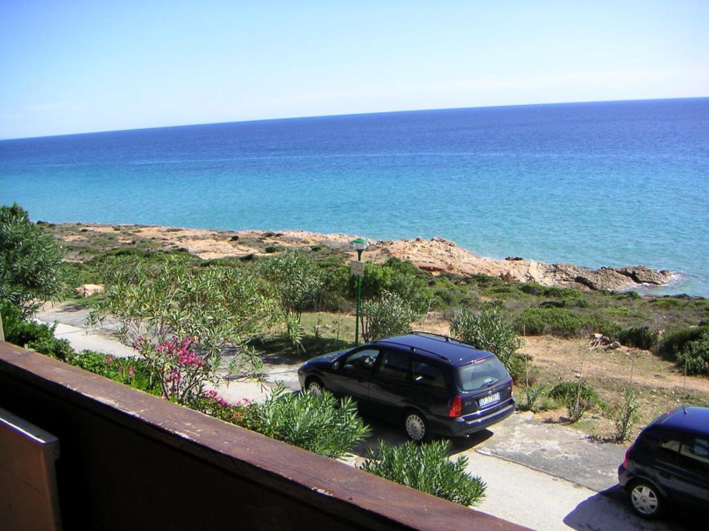ein Auto, das auf einem Parkplatz neben dem Meer parkt in der Unterkunft Appartamento Sole e Mare in Santa Margherita di Pula