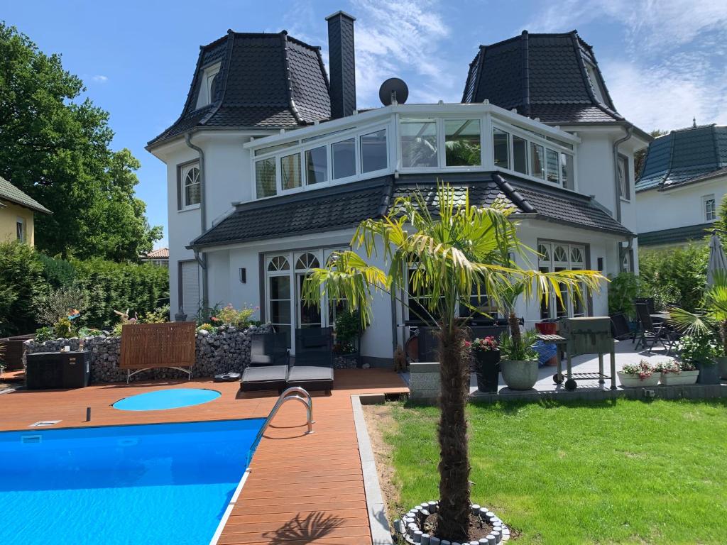 a house with a swimming pool in front of it at Villa Fallingstar in Bad Saarow