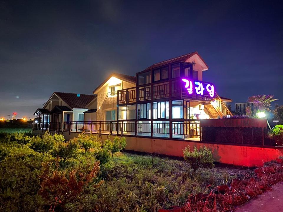 a house with a neon sign on top of it at Jeju Gillime Pension in Jeju