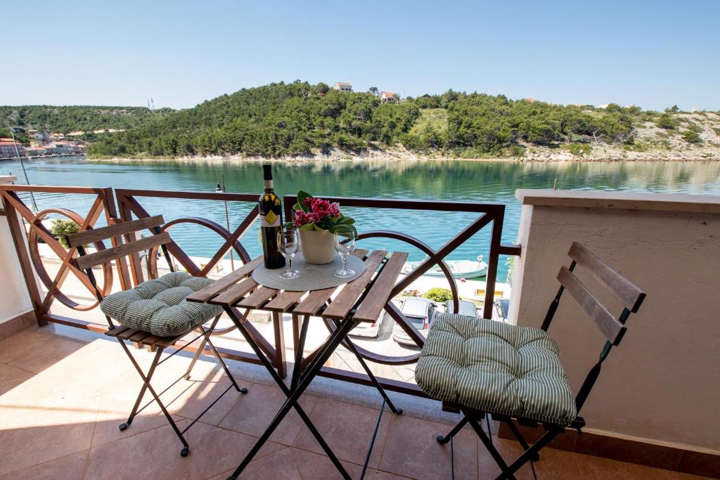 een tafel en stoelen op een balkon met uitzicht op het water bij Apartment Blašković in Novigrad Dalmatia