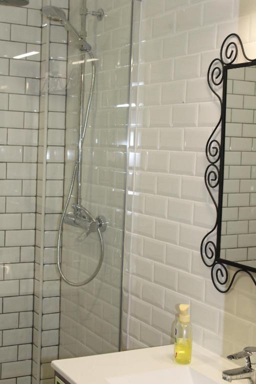 uma casa de banho com um chuveiro, um lavatório e um espelho. em Beach front apartment 1 em Sagres