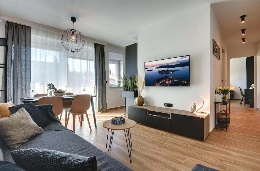 uma sala de estar com um sofá e uma sala de jantar em Giardini Penthouse apartment Pula em Pula