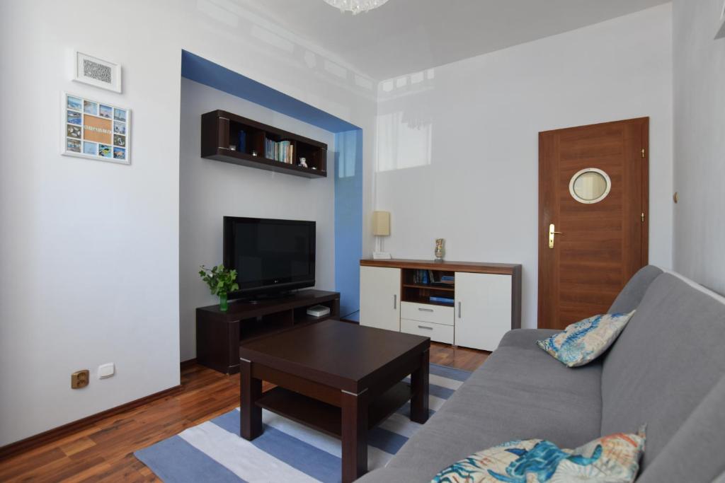 a living room with a couch and a tv at Apartament Kamienna in Gdynia