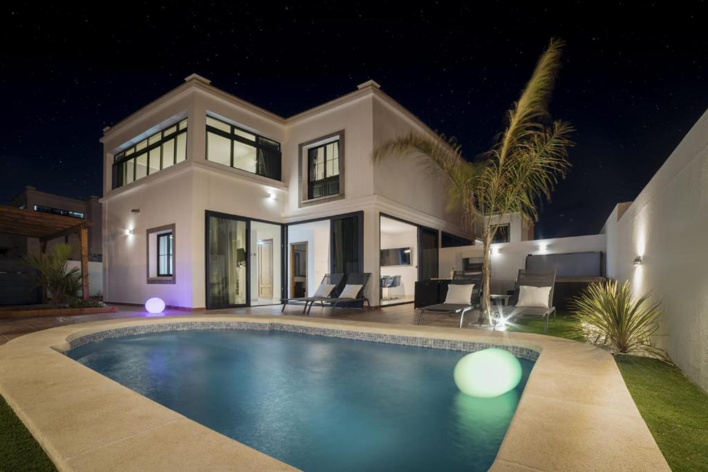 a house with a swimming pool at night at Villa Roble in Yaiza