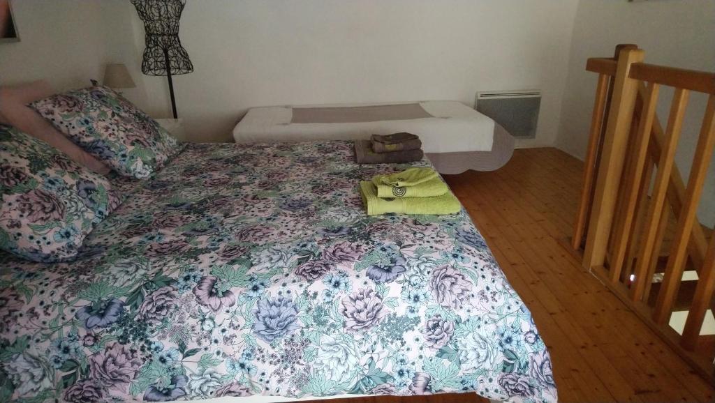 a bedroom with a bed with a flowered bedspread at Les Landes De Mauchat in Saint-Martin-de-Fressengeas