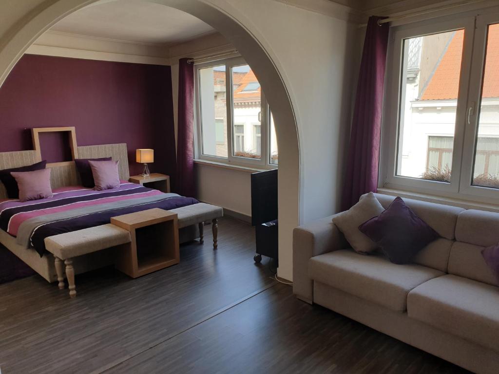 una camera con letto, divano e finestre di B&B Luxe Suites 1-2-3 ad Anversa