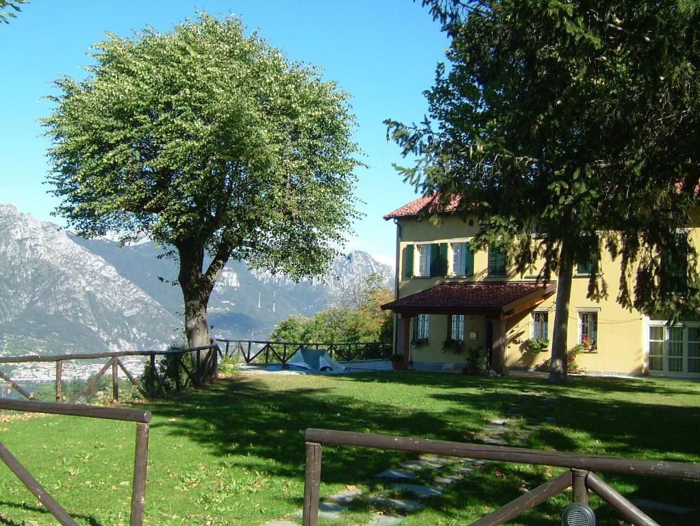 a house with a tree and a fence at Antica Locanda La Tinara del Belvedere - Romantic Dreams - in Galbiate