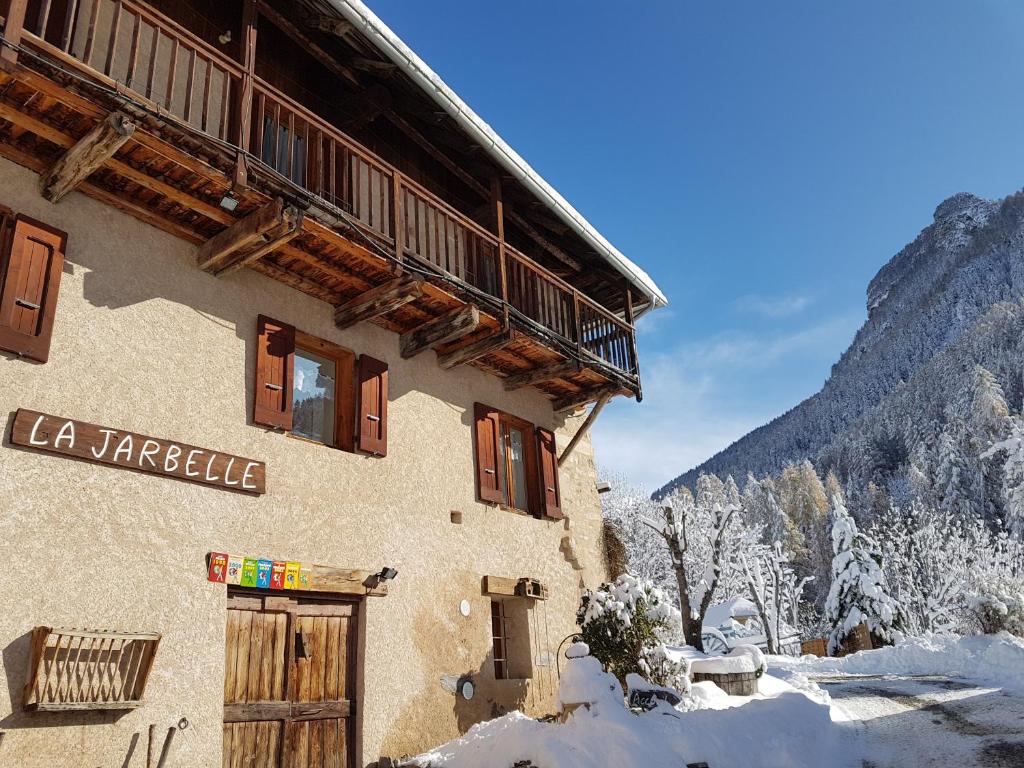a building with a sign on it in the snow at LA JARBELLE - Gîte et Spa in Les Orres