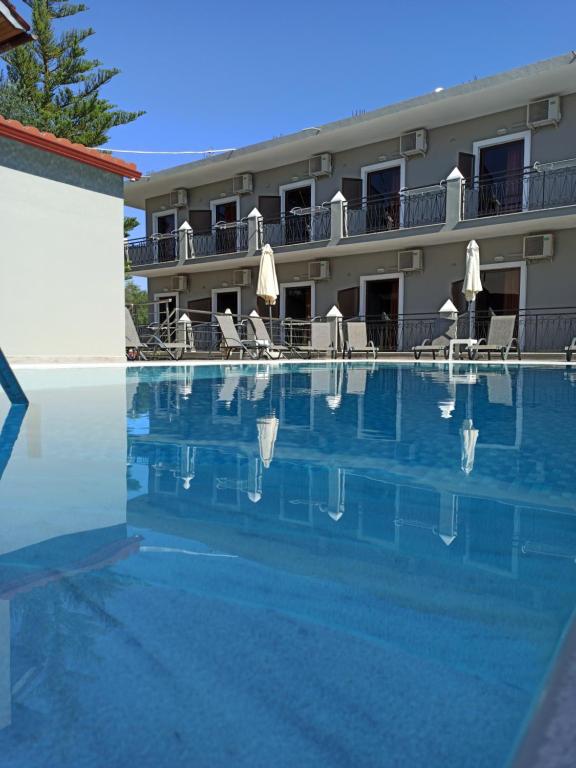 a swimming pool in front of a hotel at Dionisos Apts Gouvia by Estia in Corfu