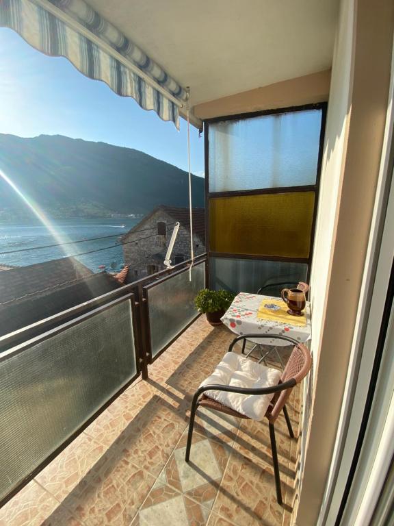 un balcon avec une table et des chaises et une vue dans l'établissement Apartments Vučinović, à Tivat