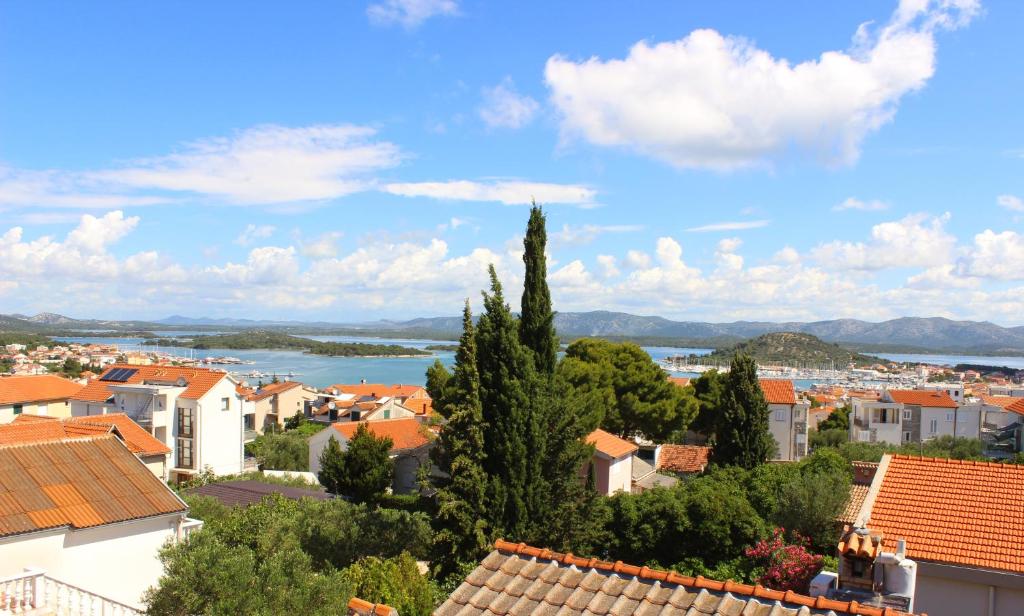 a view of a town with orange roofs and a lake at Apartments Villa Arta in Murter