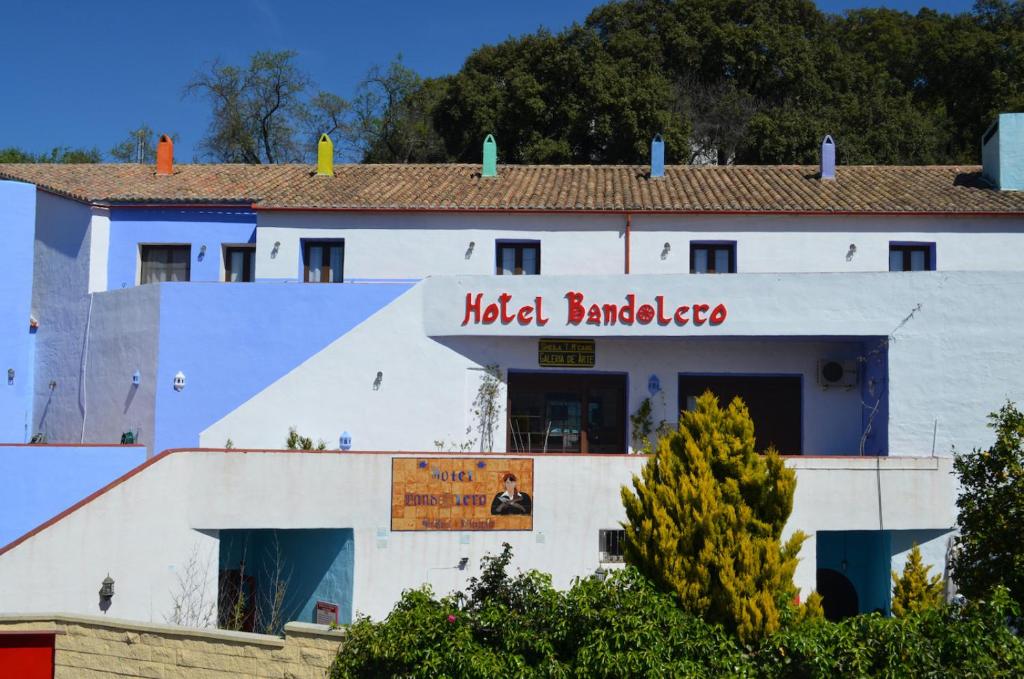 a white building with a sign on it at Hotel Restaurante Bandolero in Júzcar