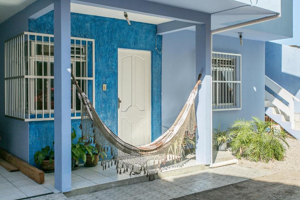 een blauw huis met een hangmat op de veranda bij Casa 150m da praia em pátio familiar in Florianópolis