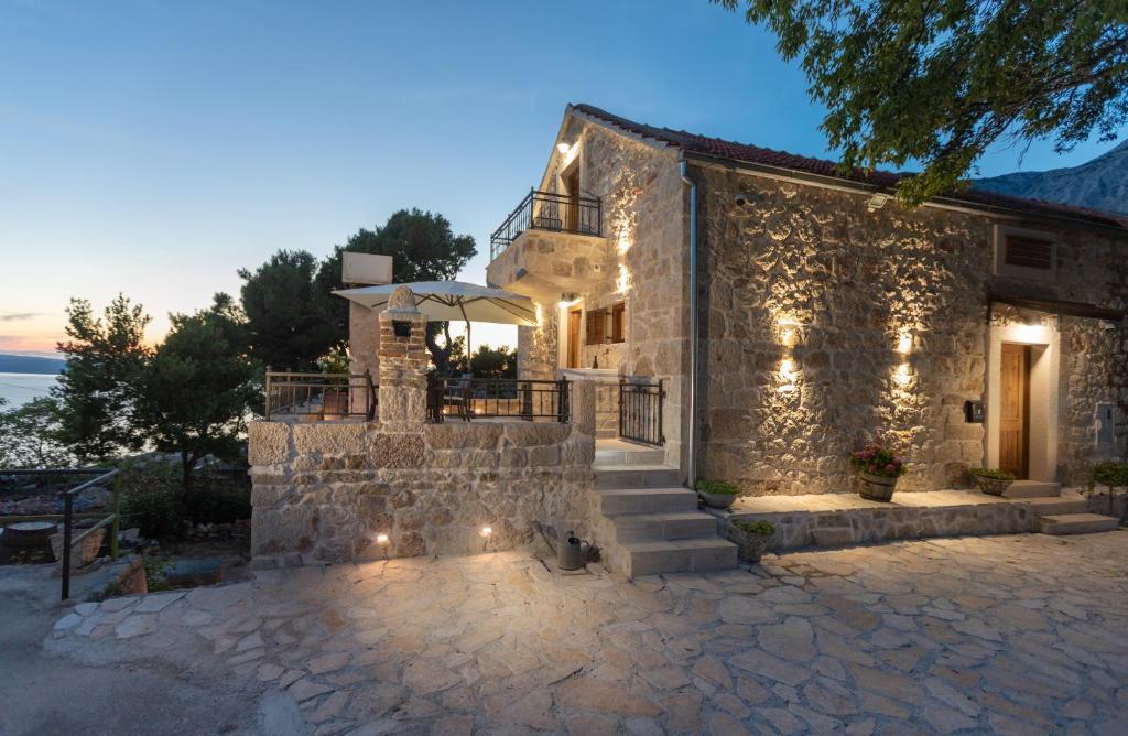 a stone house with lights on the side of it at Ivićev san in Tučepi