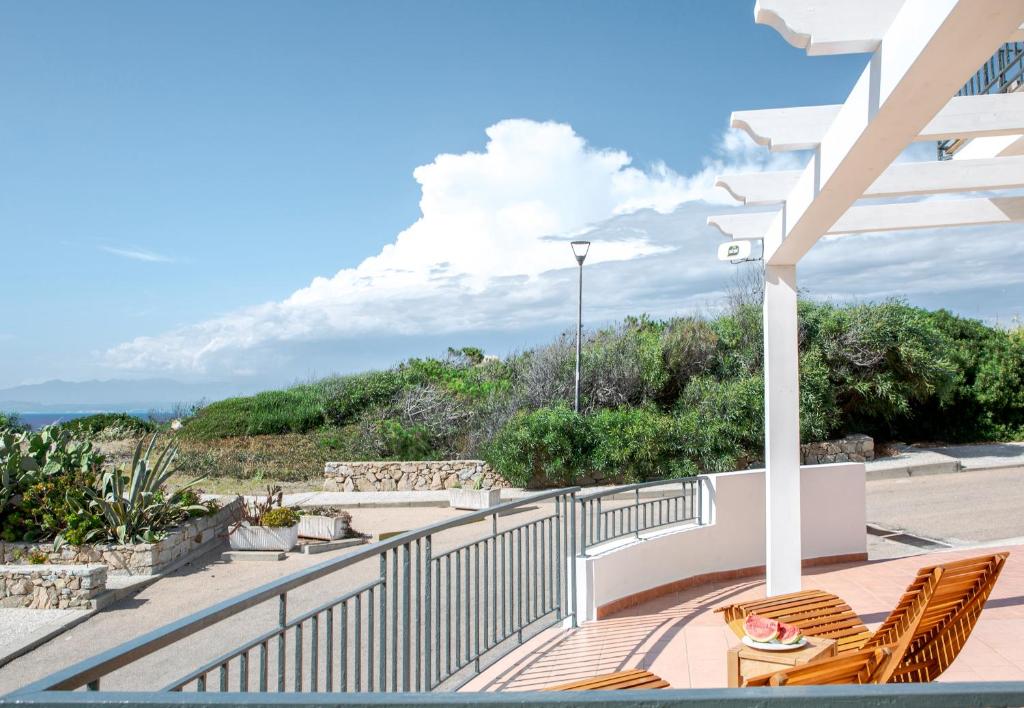 Un balcón con sillas y vistas al océano. en B&B La Torre Elite en Santa Teresa Gallura