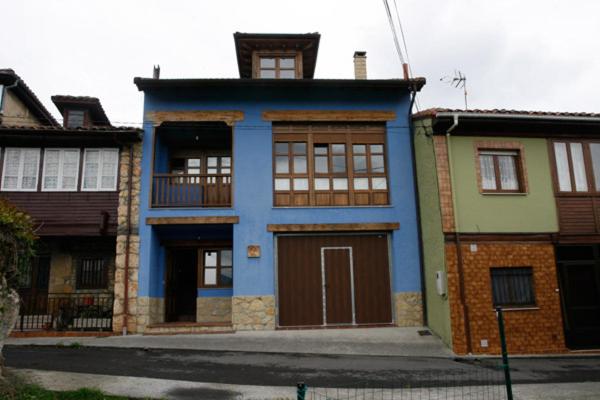 uma casa azul ao lado de uma rua em Casa Carmen em Infiesto