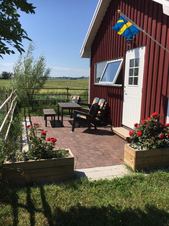 a flag is flying on the porch of a red barn at Stuga nära havet in Ystad