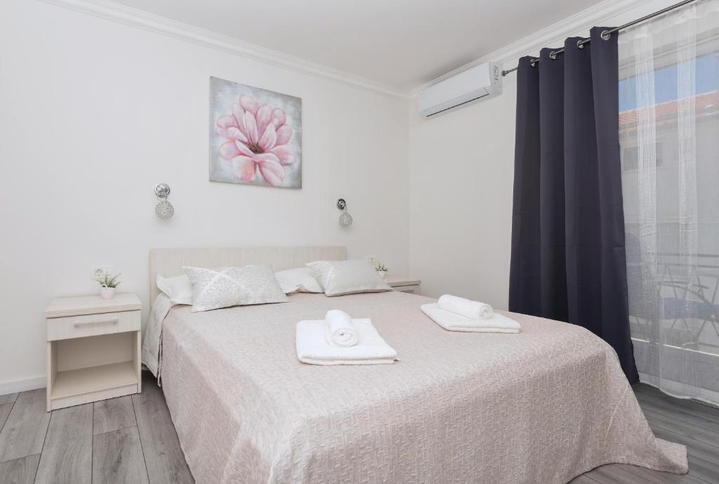 een slaapkamer met een bed met twee handdoeken erop bij Apartments PETRUSIC in Makarska