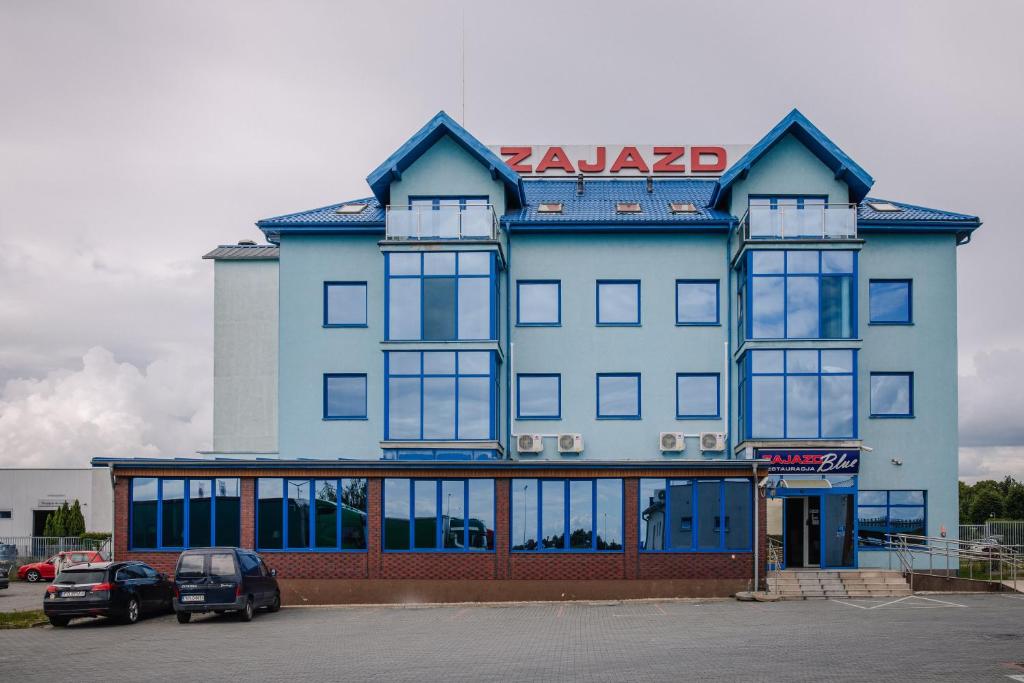 a large blue building with a akaze sign on it at Zajazd Blue in Stare Miasto