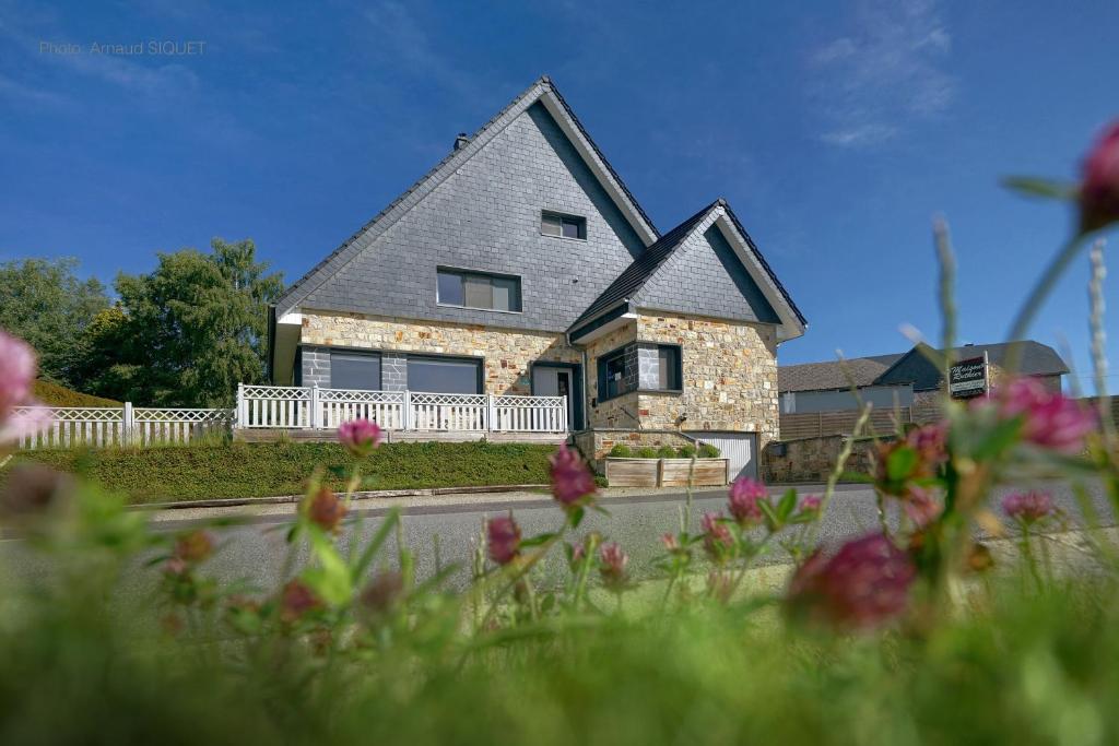 a house on a street with flowers in front of it at B&B Maison Ruthier in Waimes