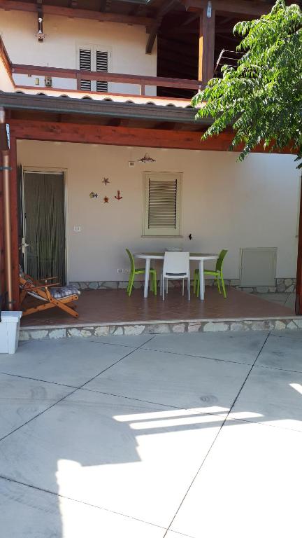 eine Terrasse mit einem Tisch und Stühlen vor einem Gebäude in der Unterkunft Casa Vacanza Demi in Alcamo Marina