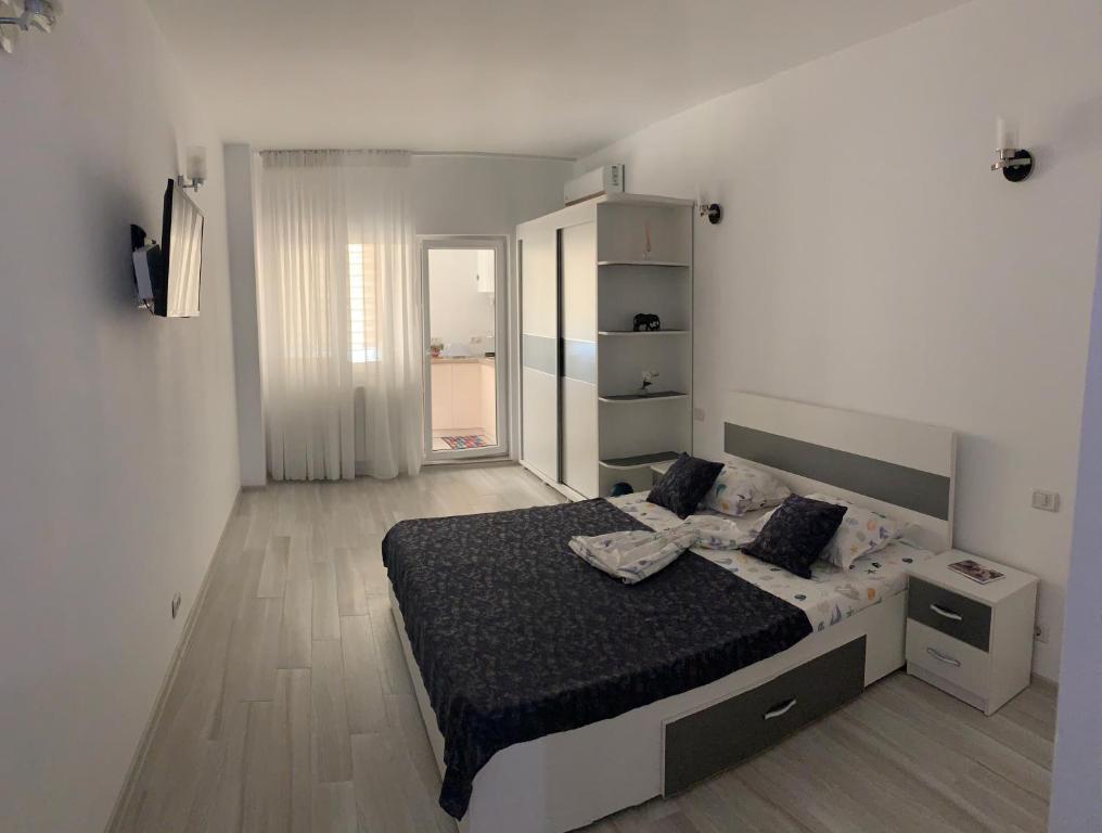 ein Schlafzimmer mit einem Bett in einem weißen Zimmer in der Unterkunft Sunny in Eforie Nord