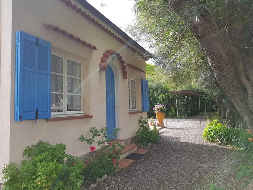 a house with blue shutters and a window at LiseManu in Juan-les-Pins