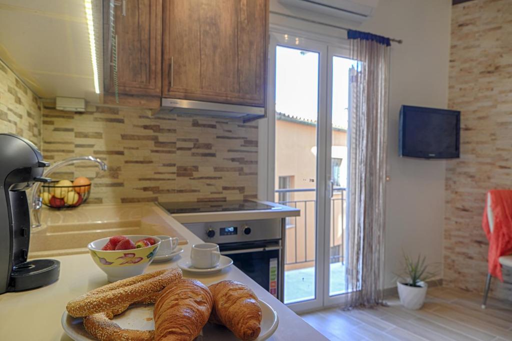 eine Küche mit Croissants und einer Schale mit Obst auf der Theke in der Unterkunft Renas Cosy Apartment in Korfu-Stadt