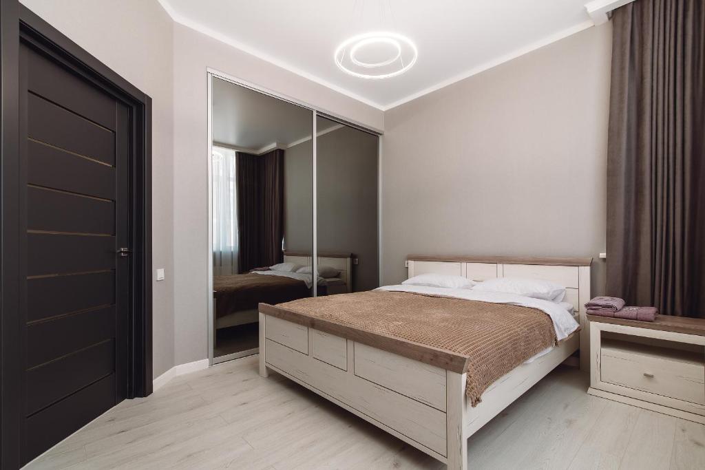 een slaapkamer met een bed en een grote spiegel bij МОРЕ 5 мин Французский бульвар спальных мест 6 in Odessa