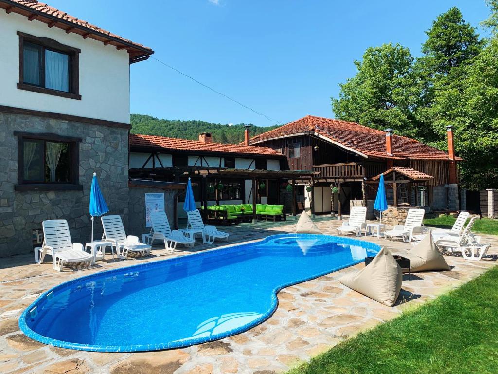 a swimming pool in front of a house at Карамановите къщи in Apriltsi