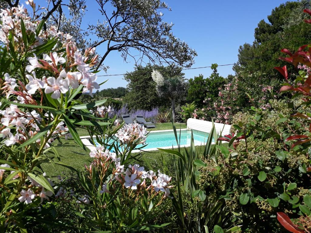 a pool in the middle of a garden with flowers at Parfums de Provence "Le Lavandin" Piscine chauffée & Spa in Vaison-la-Romaine