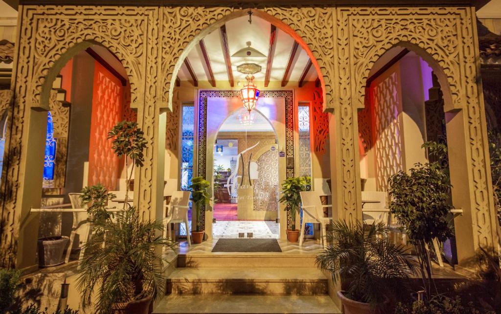 - l'entrée d'un bâtiment avec un couloir orné de plantes dans l'établissement Hotel Tarek, à Chefchaouen