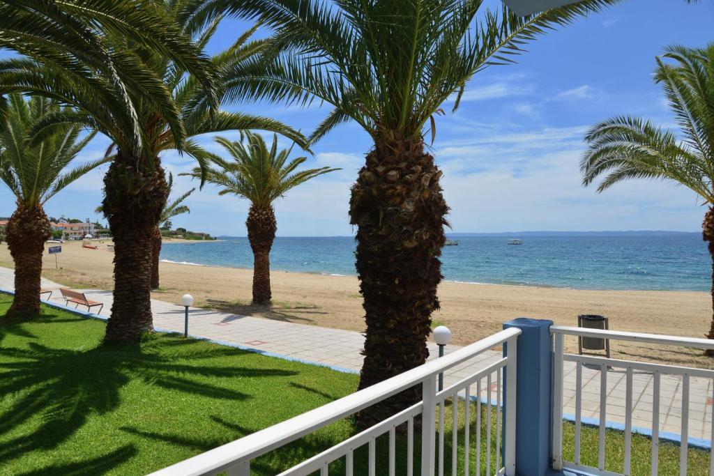 un balcón con palmeras y la playa en Olympion Beach Hotel, en Gerakini