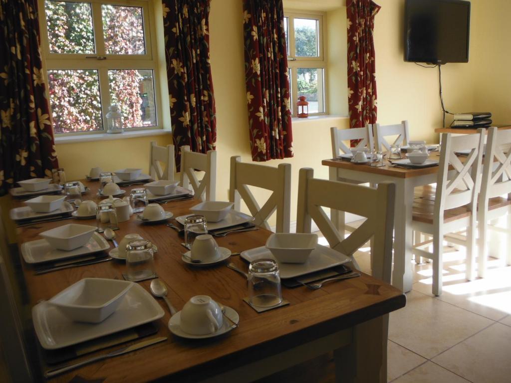 a dining room with a wooden table with dishes on it at Inspiration Lodge in Anascaul
